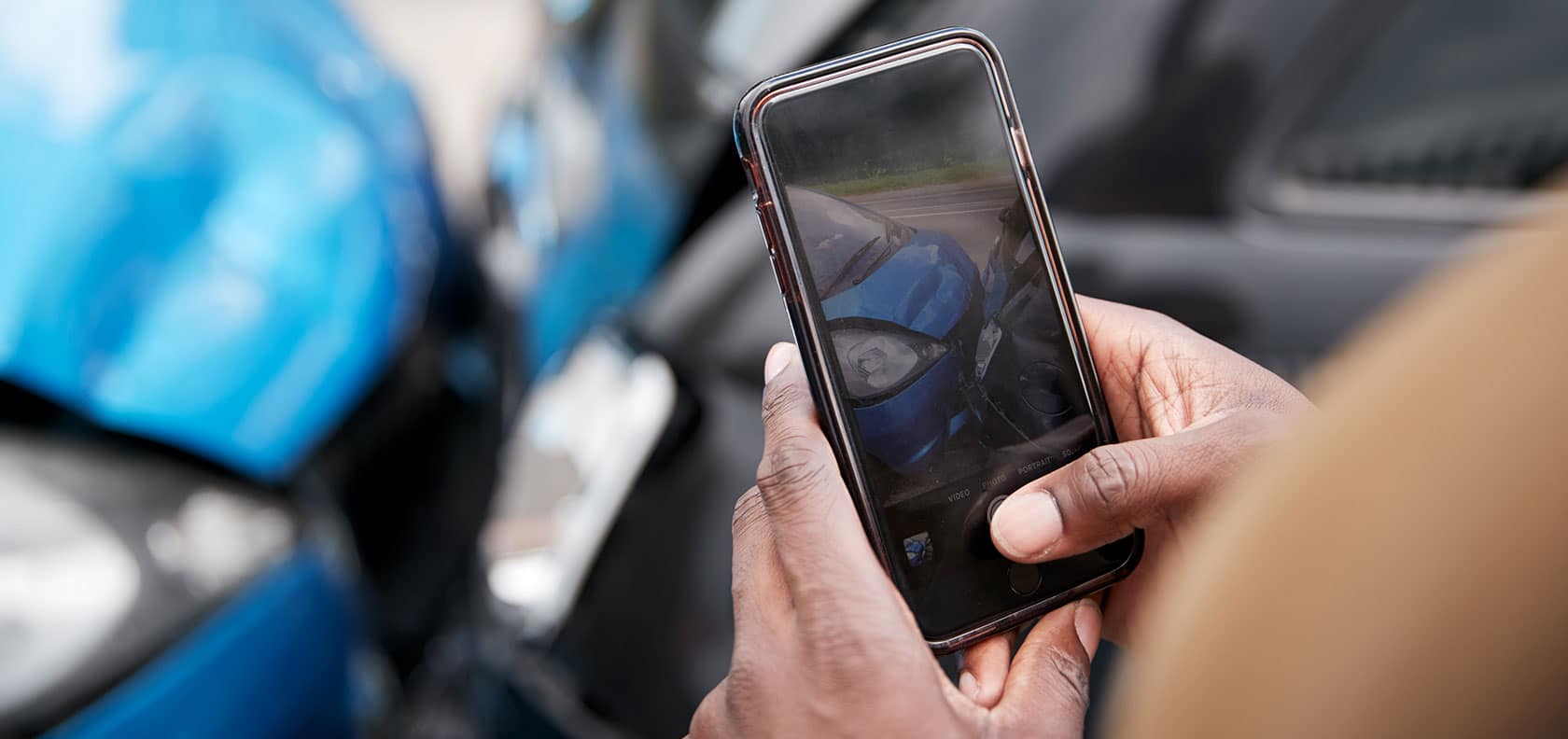 Driver who has had an accident taking a photo with the cell phone of the car in bad condition.