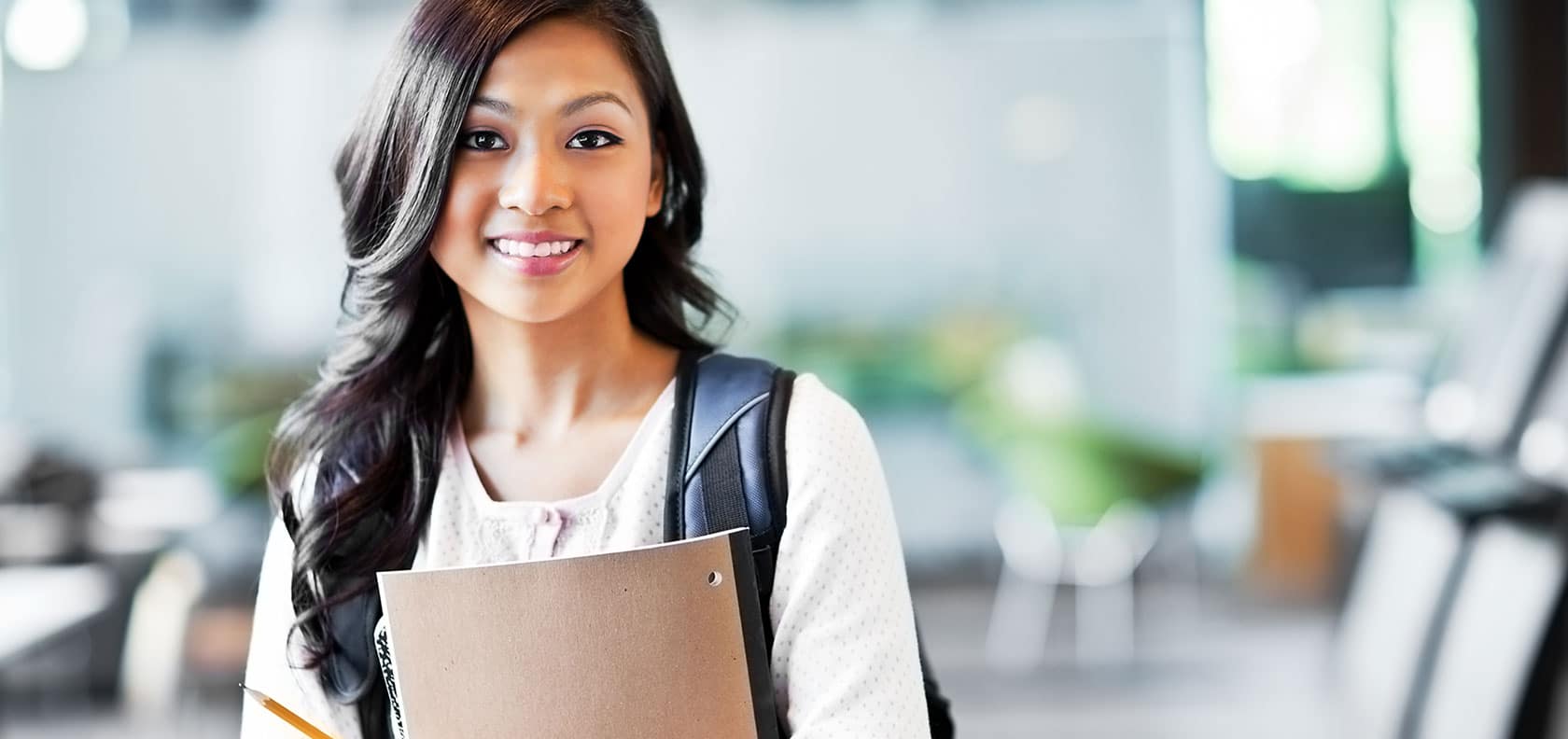 Student at school holding his notes with a backpack.