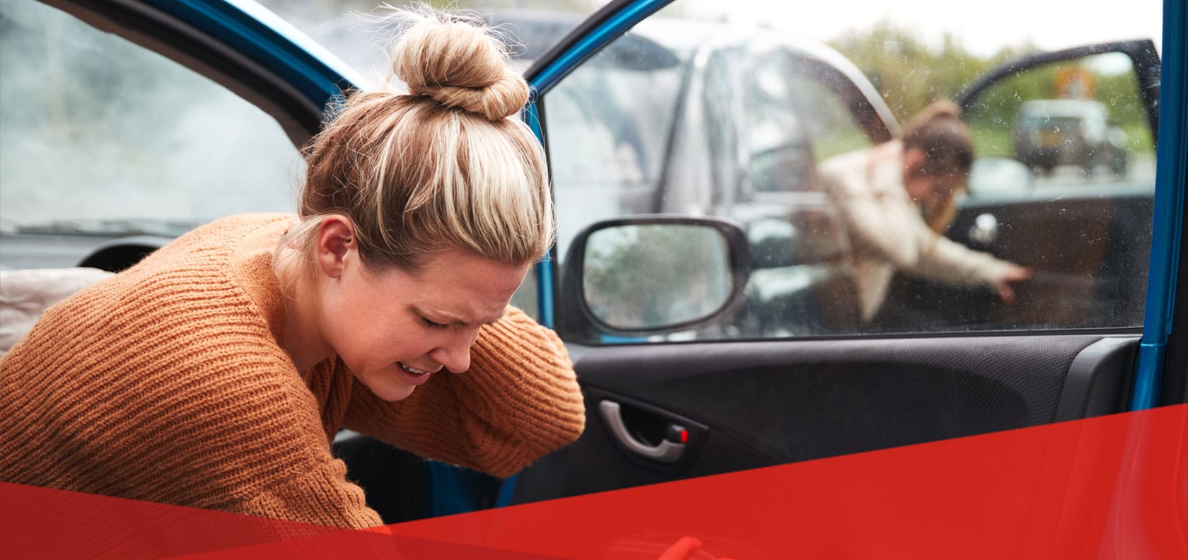 woman clutches back of her neck in car doorway